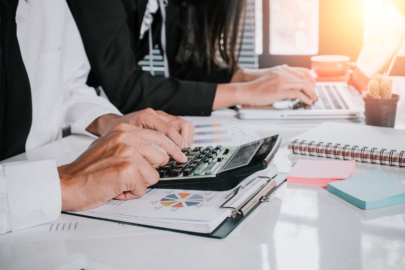Geschäftsteam unter Verwendung des Taschenrechners und Laptop-Computers, zum mit Finanzdaten zu arbeiten stockfoto