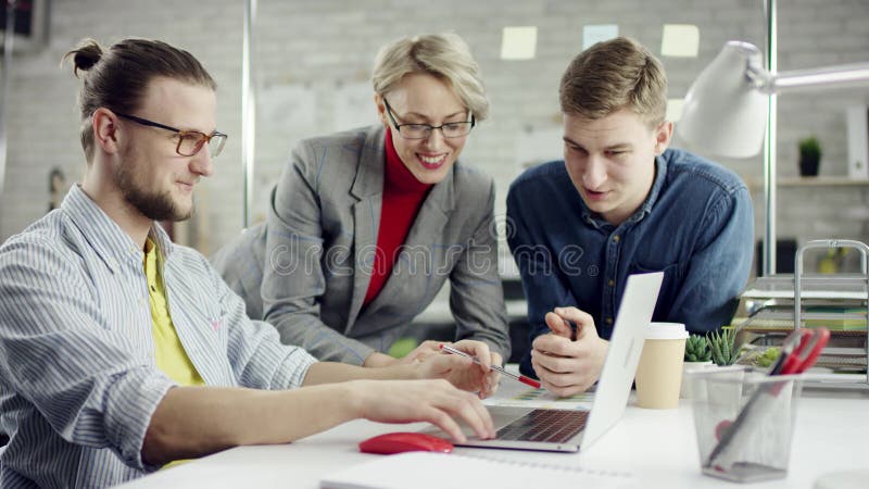 Geschäftsteam junger Leute, die über Projekte diskutieren, die sich durch die Zusammenarbeit mit tausendjährigen Gruppen amüsieren