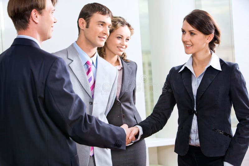 Businessman and businesswoman shaking hands in the hall. Businessman and businesswoman shaking hands in the hall