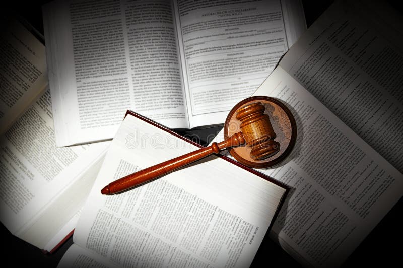 Assorted open law books with legal gavel, in dramatic light. Assorted open law books with legal gavel, in dramatic light