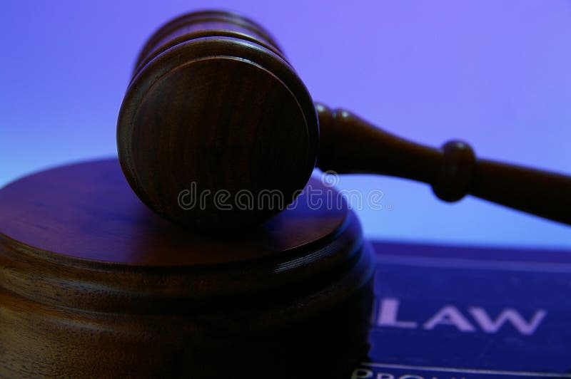 Judges court gavel on a law book, against blue background. Judges court gavel on a law book, against blue background