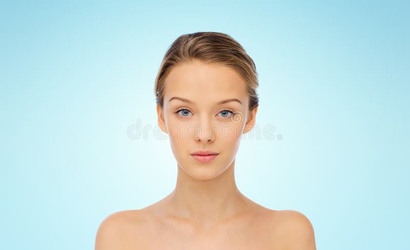 Gesicht der jungen Frau mit bloßen Schultern über Blau lizenzfreie stockfotos Gesicht der jungen Frau mit bloßen Schultern über Blau lizenzfreie stockfotos