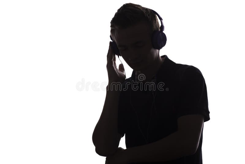 Gesichtsprofilschattenbild des Musikfreundjugendlichen hörend auf Lieblingslied in den Kopfhörern, hübscher junger Mann auf Weiß stockbild Gesichtsprofilschattenbild des Musikfreundjugendlichen hörend auf Lieblingslied in den Kopfhörern, hübscher junger Mann auf Weiß stockbild