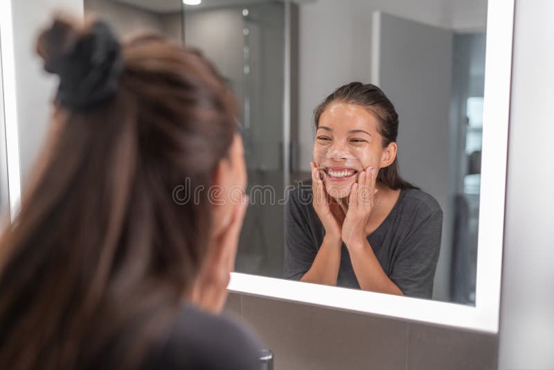 Gesichtswäsche scheuern junge Asiatinreinigung mithilfe der Gesichtsbehandlung die exfoliating Hautreinigung toter Zellen und Öl