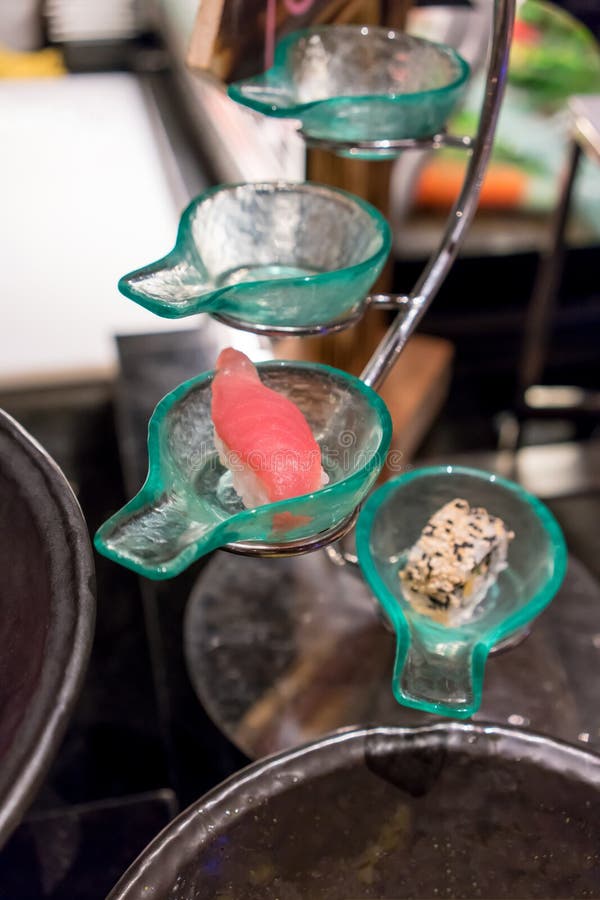 Gesloten omhoog tonijnsushi in glaslepel gevormde kom die op candl plaatsen stock afbeelding Gesloten omhoog tonijnsushi in glaslepel gevormde kom die op candl plaatsen stock afbeelding