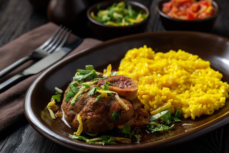 Gesmoorde die kalfsvleessteel, ossobuco, met risotto en gremolata wordt gediend royalty-vrije stock afbeelding Gesmoorde die kalfsvleessteel, ossobuco, met risotto en gremolata wordt gediend royalty-vrije stock afbeelding