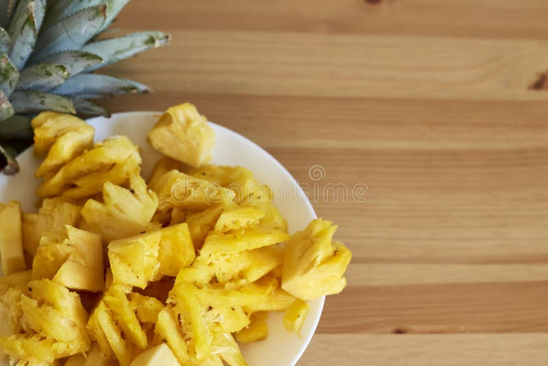 Gesneden ananas op een wit bord op hout stock afbeelding