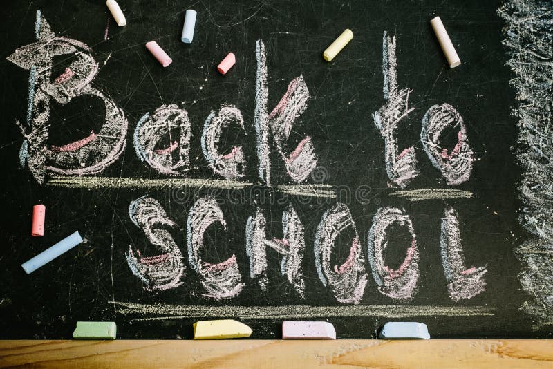 an inscription written in chalk back to school on an old blackboard. an inscription written in chalk back to school on an old blackboard