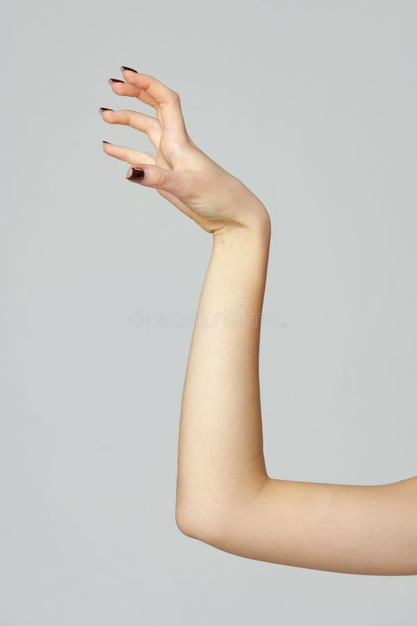 Gesto di mano della giovane donna sullo sfondo grigio fotografia stock libera da diritti