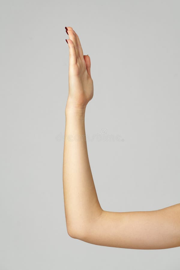 Gesto di mano della giovane donna sullo sfondo grigio fotografia stock libera da diritti