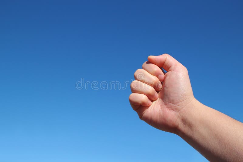 Gesto masculino del apretón de la mano en el cielo azul foto de archivo libre de regalías Gesto masculino del apretón de la mano en el cielo azul foto de archivo libre de regalías