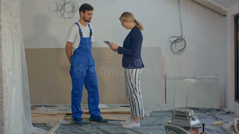 Gestori di costruzione e ingegneri che lavorano con una tavoletta nel cantiere