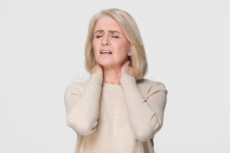 Gestörte glaubende Nackenschmerzen der reifen Frauenmassage lokalisiert auf Hintergrund stockfotografie