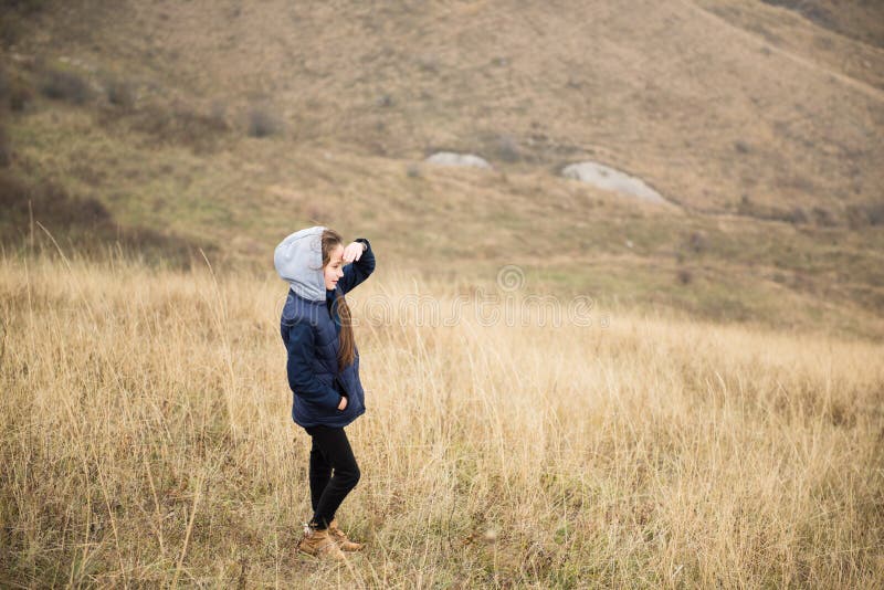 Gesunde, aktive kleine, kaukasische Mädchen mit Jacke und Hoodie, die bei Outdoor-Wandersport auf Distanz schauen lizenzfreie stockfotos Gesunde, aktive kleine, kaukasische Mädchen mit Jacke und Hoodie, die bei Outdoor-Wandersport auf Distanz schauen lizenzfreie stockfotos