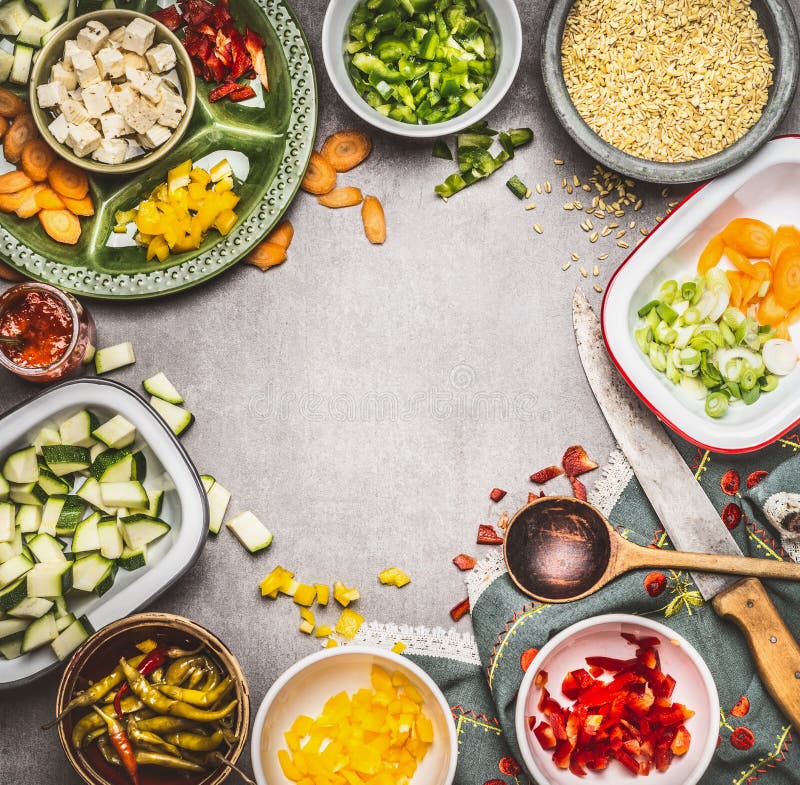 Gesunde Vorbereitung des vegetarischen Tellers mit gewürfeltem Feta, geschnittenem Gemüse in den Schüsseln, Perlgerste, Löffel un lizenzfreies stockfoto Gesunde Vorbereitung des vegetarischen Tellers mit gewürfeltem Feta, geschnittenem Gemüse in den Schüsseln, Perlgerste, Löffel un lizenzfreies stockfoto