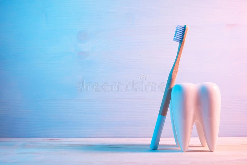 Gesunde Zähne Konzept, Zahnmodell mit Zahnbürste auf hölzernem blauem Hintergrund lizenzfreies stockfoto
