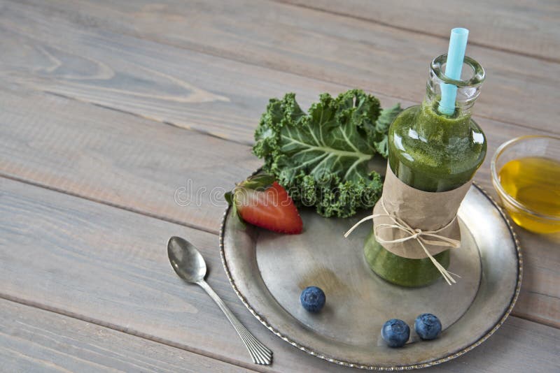 Gesunder grüner Smoothie mit Kohl, Erdbeeren, Blaubeeren und Honig in der Flasche mit Aufkleber auf rustikalem hölzernem Hintergr stockbilder Gesunder grüner Smoothie mit Kohl, Erdbeeren, Blaubeeren und Honig in der Flasche mit Aufkleber auf rustikalem hölzernem Hintergr stockbilder
