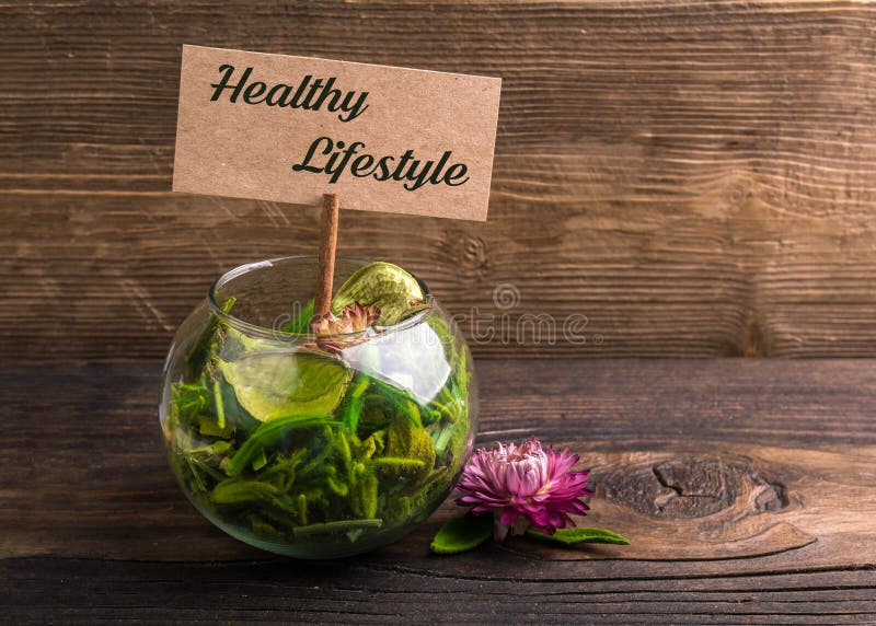 Healthy lifestyle text on sign board with flower and leafs on wood. Healthy lifestyle text on sign board with flower and leafs on wood