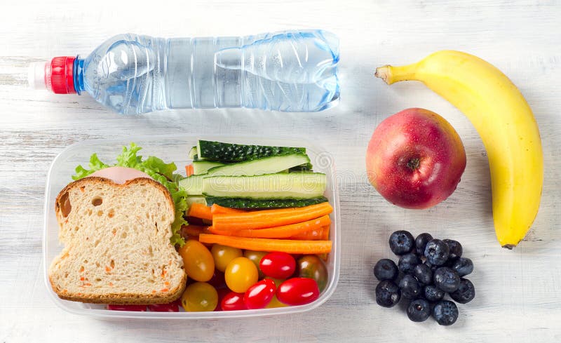 Healthy lunch box with sandwich and fresh vegetables, bottle of water. Healthy eating concept. Top view. Healthy lunch box with sandwich and fresh vegetables, bottle of water. Healthy eating concept. Top view