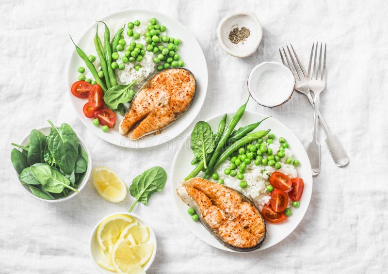 Healthy balanced mediterranean diet lunch - baked salmon, rice, green peas and green beans on a light background, top view. Flat lay. Healthy balanced mediterranean diet lunch - baked salmon, rice, green peas and green beans on a light background, top view. Flat lay