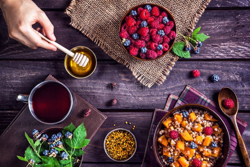 Healthy breakfast with pumpkin porridge, berries and herbal tea with honey at village summer house. Healthy breakfast with pumpkin porridge, berries and herbal tea with honey at village summer house