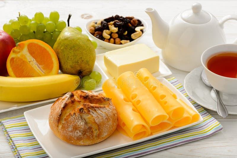 Gesundes Frühstück mit Käse, frischem Brötchen, frischen Früchten und Tee stockbilder Gesundes Frühstück mit Käse, frischem Brötchen, frischen Früchten und Tee stockbilder