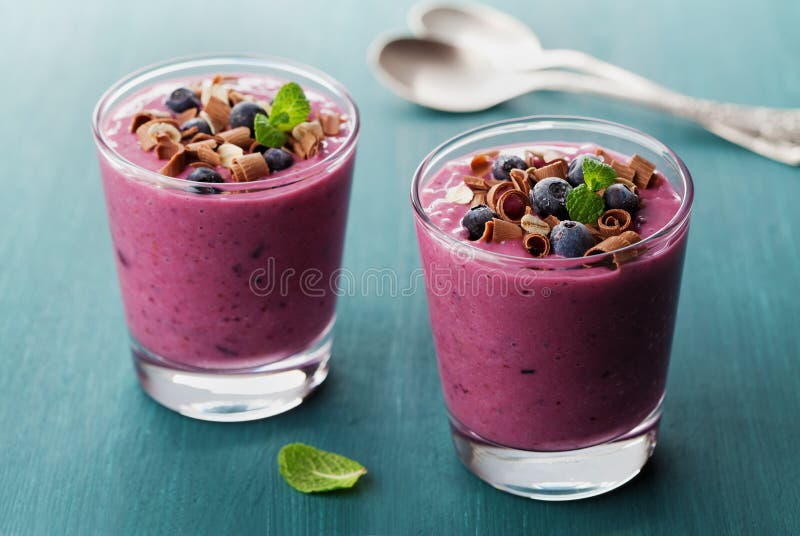 Gesundes Frühstück von Smoothie, von Nachtisch, von Jogurt oder von Milchshaken mit gefrorener Blaubeere und Hafern verzierte Sch stockbilder Gesundes Frühstück von Smoothie, von Nachtisch, von Jogurt oder von Milchshaken mit gefrorener Blaubeere und Hafern verzierte Sch stockbilder