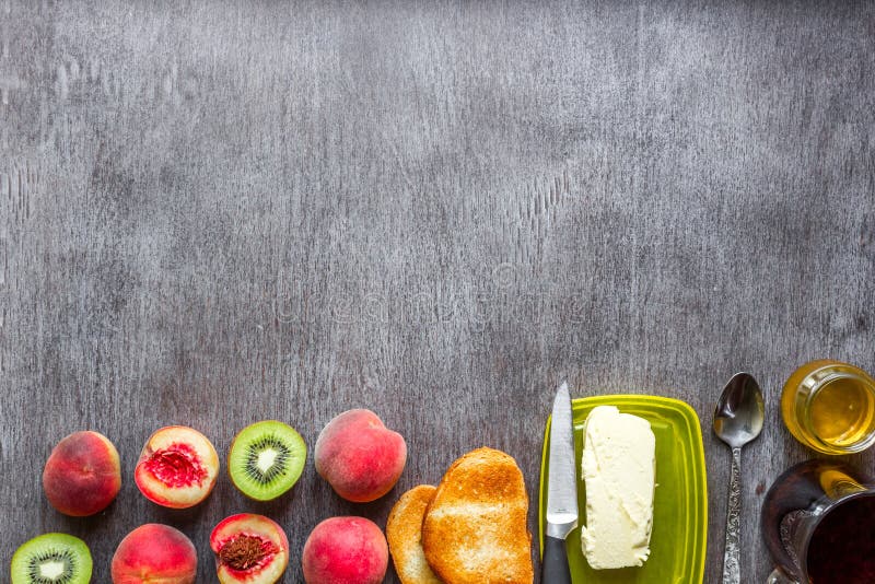 gesundes Frühstückskonzept Toast mit Butter, Honig, Früchten und Tee über dunklem hölzernem Hintergrund stockfoto gesundes Frühstückskonzept Toast mit Butter, Honig, Früchten und Tee über dunklem hölzernem Hintergrund stockfoto