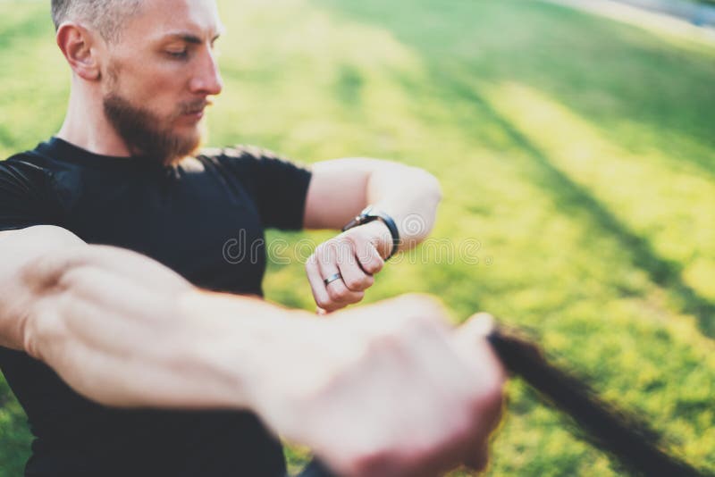 Gesundes intelligentes Lebensstilkonzept Muskulöser Athlet, der großes trainierendes TRX draußen im sonnigen Park tut Junger guta lizenzfreie stockfotografie Gesundes intelligentes Lebensstilkonzept Muskulöser Athlet, der großes trainierendes TRX draußen im sonnigen Park tut Junger guta lizenzfreie stockfotografie