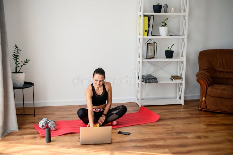 Woman Doing Fitness At Home With Video Tutorial Stock Photo