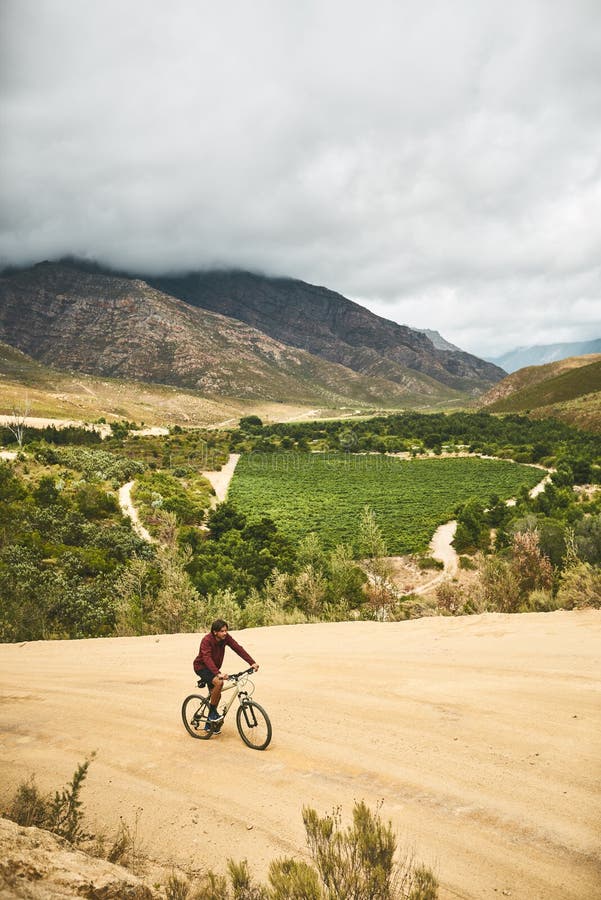 Instead of getting lost, its where you find yourself. a young man cycling along a trail. stock photos