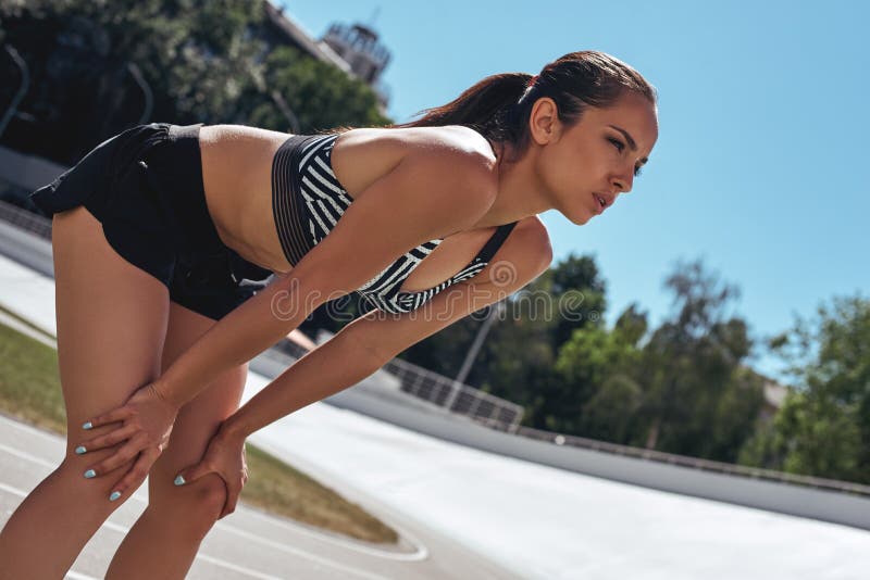 Getting ready. Runner on the stadium track. Woman summer fitness workout. Jogging, sport, healthy active lifestyle royalty free stock images Getting ready. Runner on the stadium track. Woman summer fitness workout. Jogging, sport, healthy active lifestyle royalty free stock images