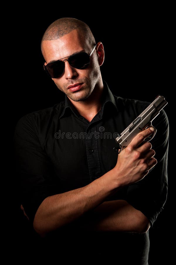Gevaarlijke mens met een kanon en zonnebril stock foto Gevaarlijke mens met een kanon en zonnebril stock foto