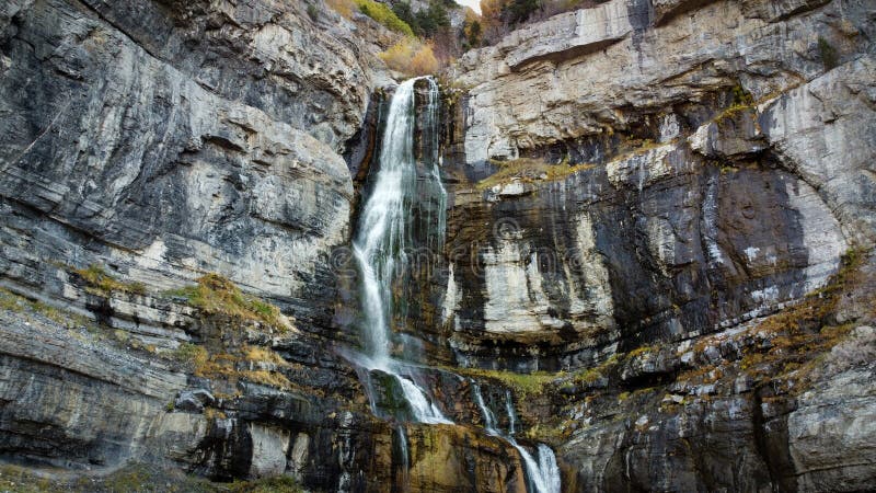 Gewaltiger Wasserfall, der einen felsigen Berghang hinabführt stockbilder
