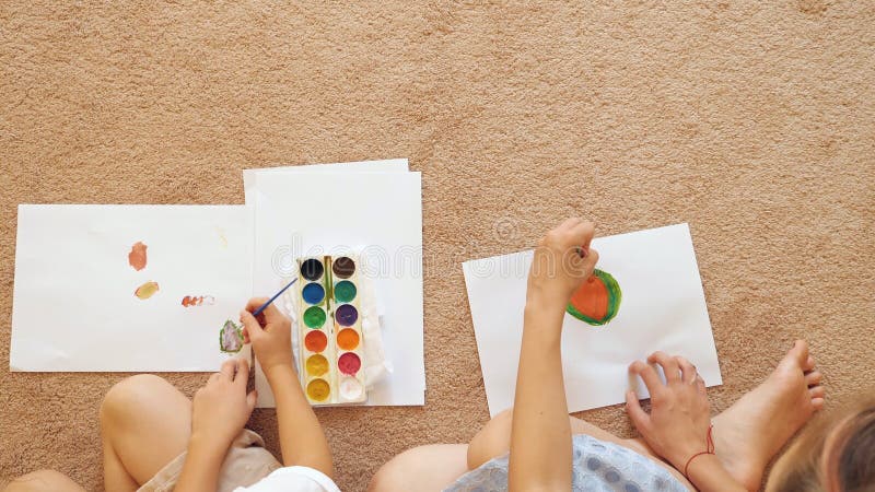 Gewassenvrouw en meisje die op papier trekken