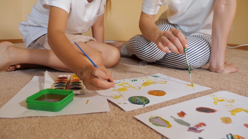 Gewassenvrouw en meisje die op papier trekken