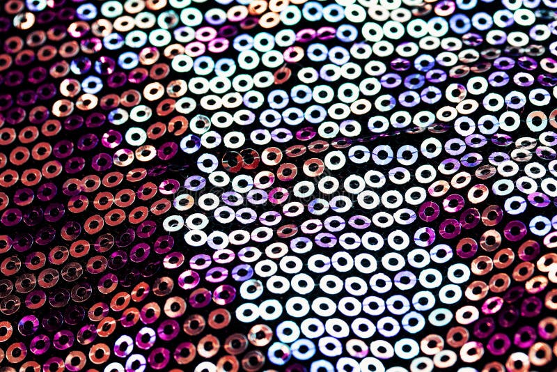 textured background of shiny round multicolored iridescent sequins sewn on fabric for a festive evening dress. textured background of shiny round multicolored iridescent sequins sewn on fabric for a festive evening dress