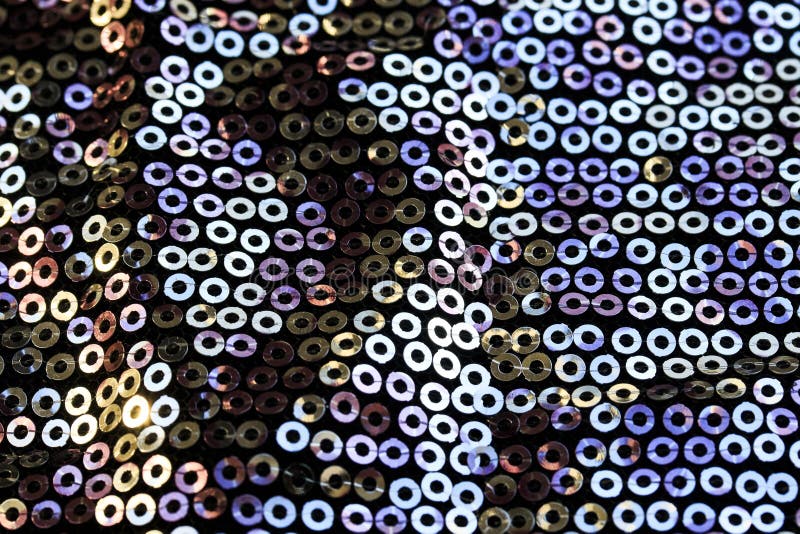 background of shiny round multicolored iridescent sequins sewn on fabric for a trendy festive evening dress. background of shiny round multicolored iridescent sequins sewn on fabric for a trendy festive evening dress