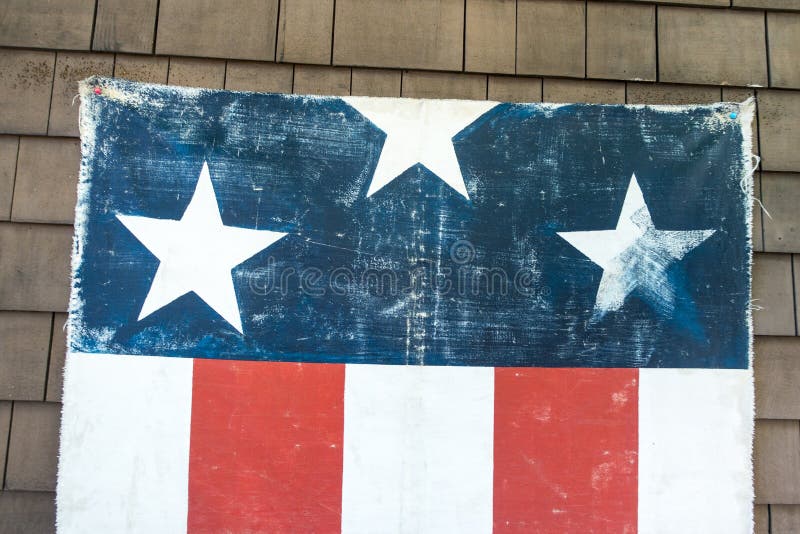 Geweven verontruste hangende Amerikaanse rode witte en blauwe vlag met drie sterren en 5 strepen aan de kant van huismuur 4 Juli royalty-vrije stock foto's Geweven verontruste hangende Amerikaanse rode witte en blauwe vlag met drie sterren en 5 strepen aan de kant van huismuur 4 Juli royalty-vrije stock foto's