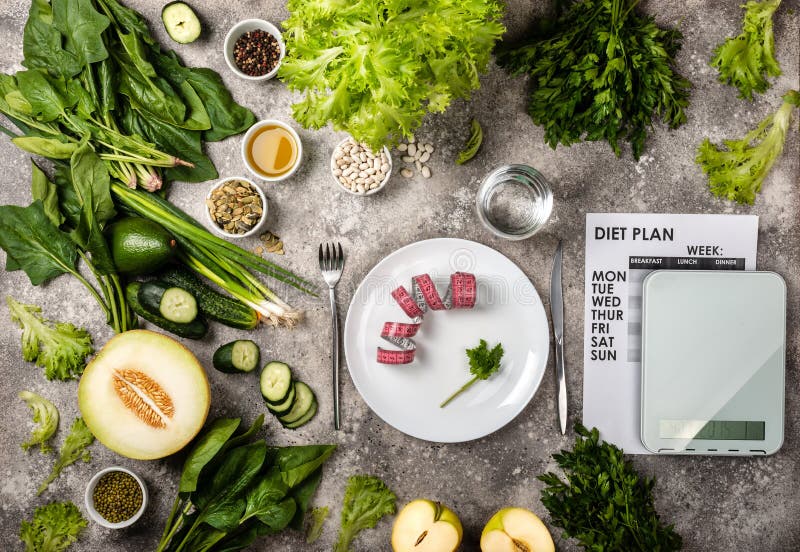 Weight loss concept. Measuring tape on the plate Kitchen scale Diet plan and Set of healthy food on the table. Top view. Weight loss concept. Measuring tape on the plate Kitchen scale Diet plan and Set of healthy food on the table. Top view.