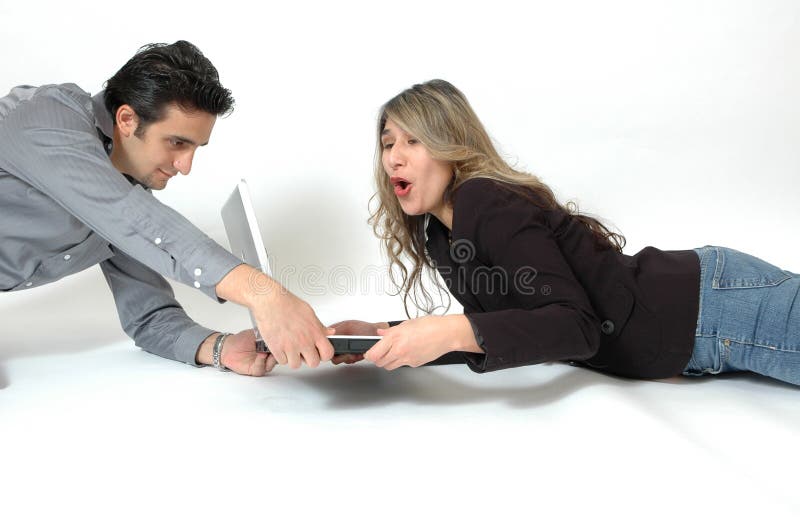 A Happy Diverse couple on white background laying on the floor and doing internet shopping. Facial expressions of shopping consumers. Couple playfully fighting over the computer. A Happy Diverse couple on white background laying on the floor and doing internet shopping. Facial expressions of shopping consumers. Couple playfully fighting over the computer.