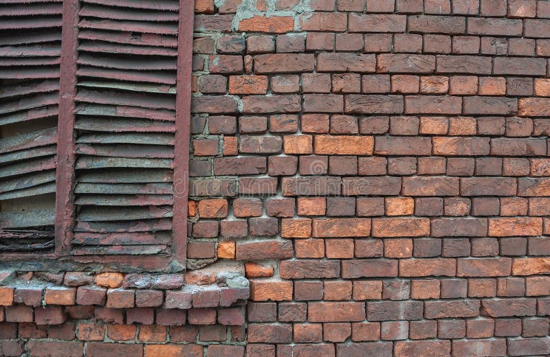 Gewogene Ziegelwand mit Peeling und rostenden Fensterläden lizenzfreie stockbilder