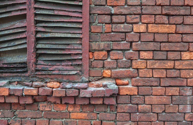 Gewogene Ziegelwand mit Peeling und rostenden Fensterläden stockbilder