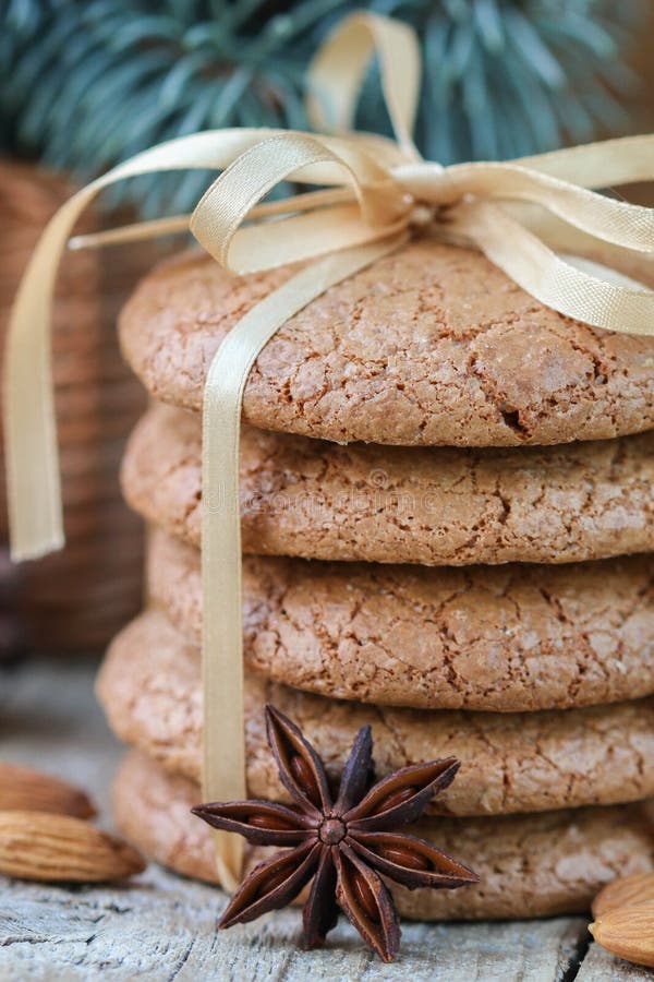 Spiced cookies with almonds. Christmas gifts. Round cookies, tied with ribbon and spruce branch in a basket on the table. Spiced cookies with almonds. Christmas gifts. Round cookies, tied with ribbon and spruce branch in a basket on the table