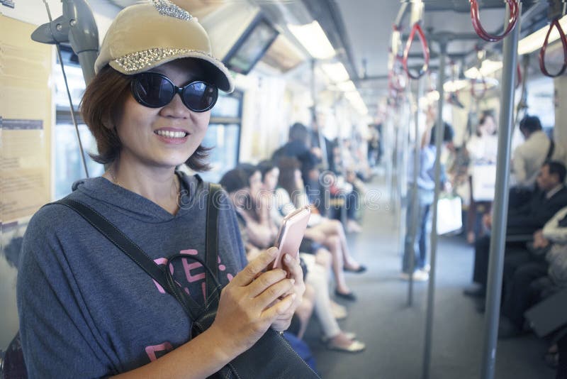 Gezicht van vrouw in hemeltrein met slim telefoon in hand gebruik voor het stadsleven en reizend thema stock foto's Gezicht van vrouw in hemeltrein met slim telefoon in hand gebruik voor het stadsleven en reizend thema stock foto's