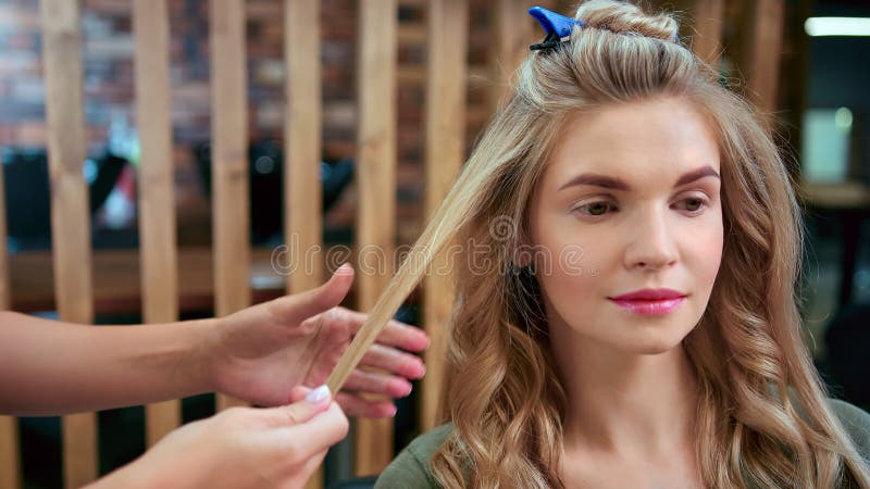 Gezicht van vrouwtje bij schoonheidssalon tijdens het maken van haarstijl. middelgrote close-up schot op rode camera van 4.000