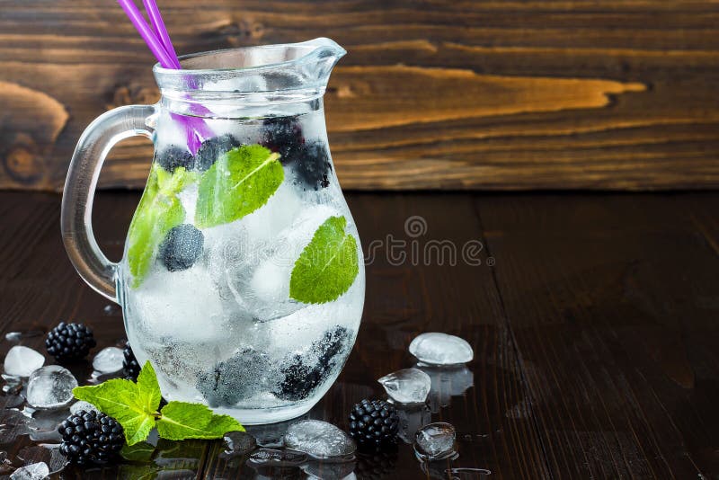 Gezond detox op smaak gebracht water met braambes en munt Koude verfrissende bessendrank met ijs op donkere houten lijst Exemplaa royalty-vrije stock foto Gezond detox op smaak gebracht water met braambes en munt Koude verfrissende bessendrank met ijs op donkere houten lijst Exemplaa royalty-vrije stock foto