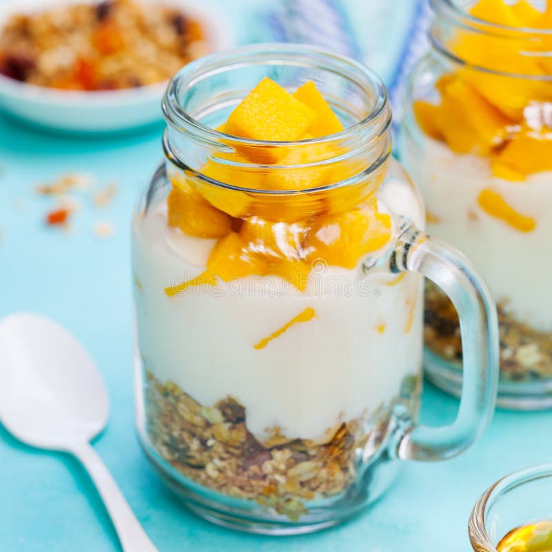 Gezond ontbijt, dessert Vers mangofruit met yoghurt en granola in kruiken Achtergrond voor een uitnodigingskaart of een gelukwens stock foto's Gezond ontbijt, dessert Vers mangofruit met yoghurt en granola in kruiken Achtergrond voor een uitnodigingskaart of een gelukwens stock foto's