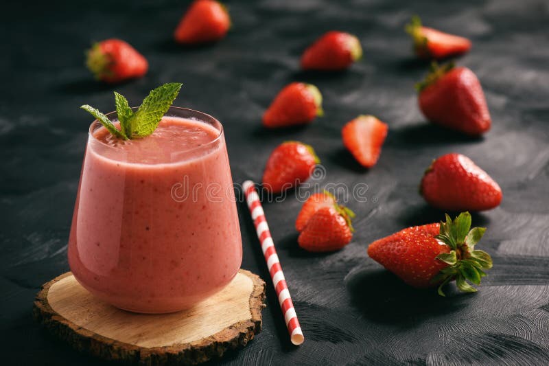 Gezond voedsel - aardbei smoothie in glas op zwarte achtergrond royalty-vrije stock afbeelding Gezond voedsel - aardbei smoothie in glas op zwarte achtergrond royalty-vrije stock afbeelding