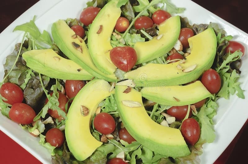 Gezonde avocadoschotel, kersentomaten, amandelsla en voor romantisch diner stock fotografie Gezonde avocadoschotel, kersentomaten, amandelsla en voor romantisch diner stock fotografie